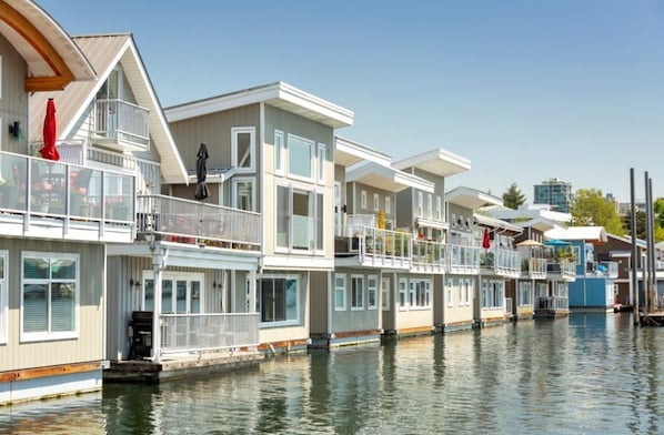 Floating homes with balconies, large windows, and a dock.
