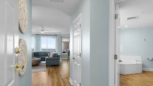 A spacious living room with a grey sofa, a wooden floor, and a view to the kitchen. - Stunning Ocean Views from this Beautiful Condo with Pool, On-Site Amenities! (Hilton Head)