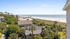 A coastal residential area with houses, a beach, and palm trees. - Stunning Ocean Views from this Beautiful Condo with Pool, On-Site Amenities! (Hilton Head)