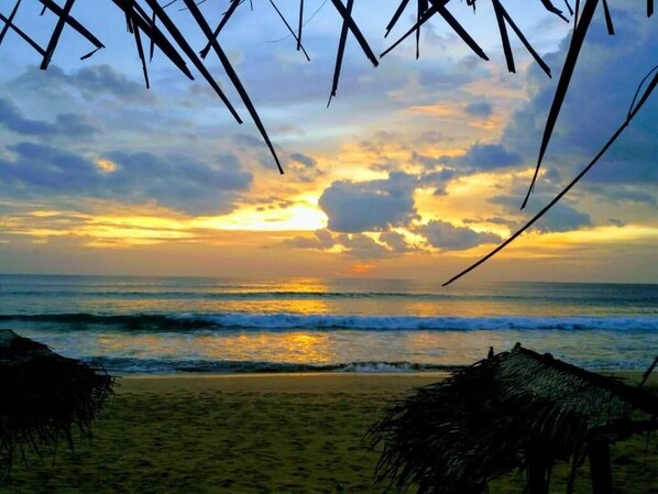 Enjoy a serene beachside escape with breathtaking ocean views and thatched huts.
