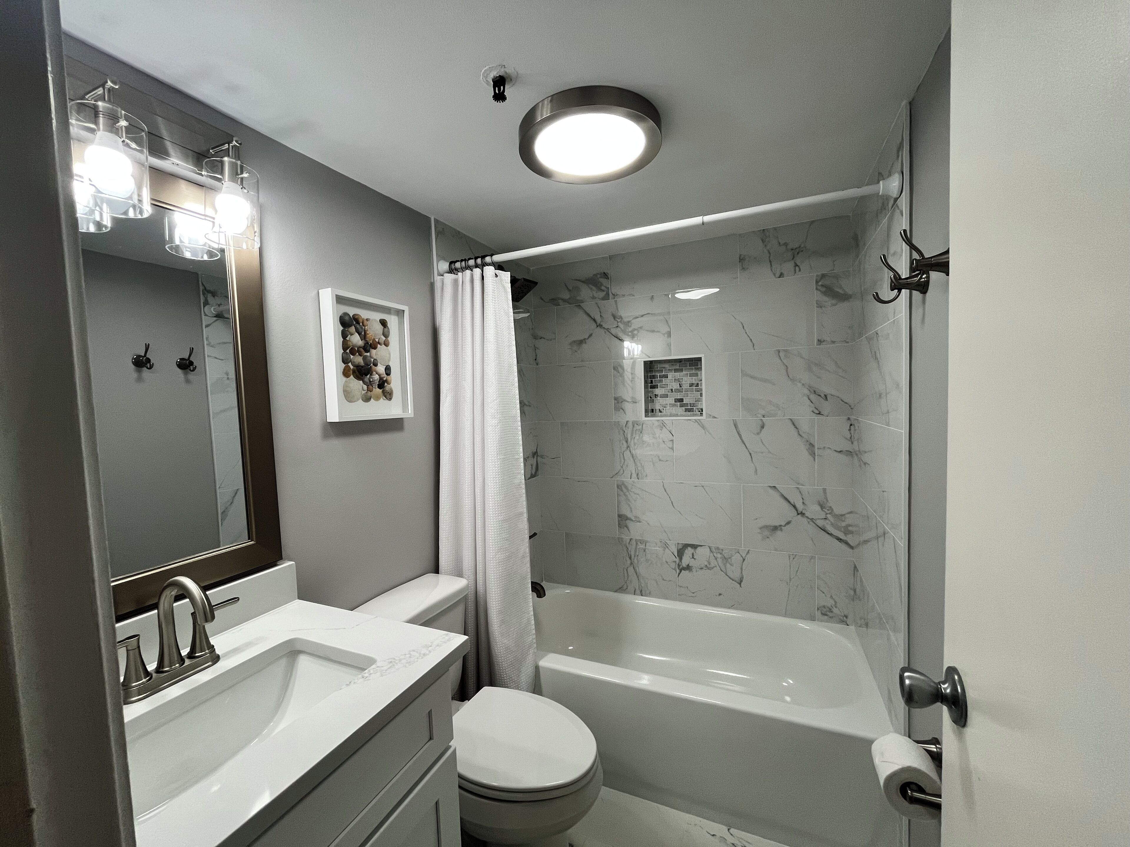 A modern bathroom with a bathtub, a toilet, and a sink.