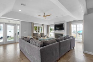 Relax in this inviting living room with a large sectional sofa, flat-screen TV, and fireplace.