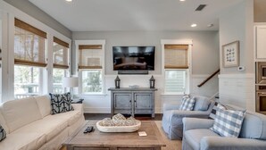 A living room with a TV, two sofas, a coffee table, and a cabinet. - 2 King Suites, 2 Resort Pools, Golf Cart & 6 Bikes! Nature Trail to the Beach! ~ Go Coastal at NatureWalk on 30A (Santa Rosa Beach)