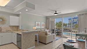 Una cucina moderna con zona pranzo, divano e vista sulla piscina.