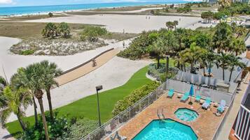 A resort with a pool area, a beach, and a view of the ocean.