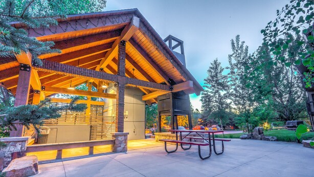 A building with a wooden structure and a stone bench in the foreground. - Cozy condo in Steamboat Springs.  Close to slopes! (Steamboat Springs)