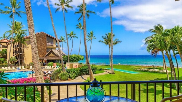 A hotel balcony with a view of the ocean, palm trees, and a swimming pool. - Best Papakea Location - Incredible Ocean View - Fully Renovated (Lahaina)