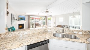 A modern kitchen with granite countertops, a dishwasher, and a stainless steel sink.