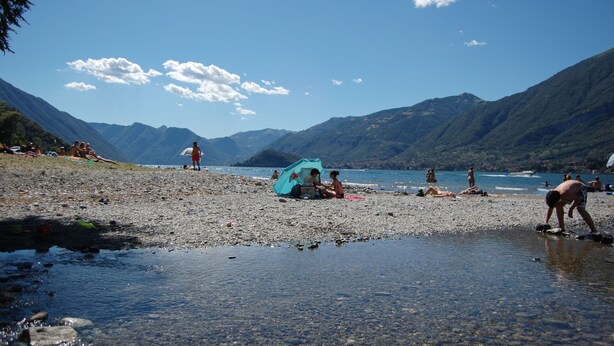 Ein Strand mit entspannten Menschen und einem Zelt.