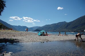 A beach with people relaxing and a tent set up. - Lake Como Family VILLA pool & garden 24 pax (Barni)