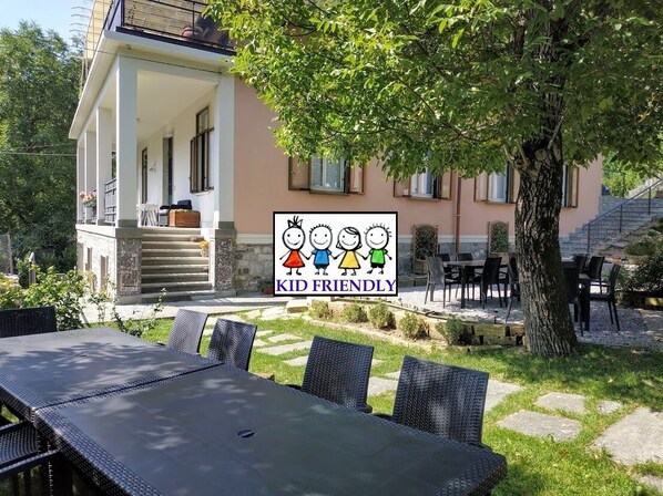 Une maison dotée d’un patio aménagé avec du mobilier d’extérieur et un jardin.
