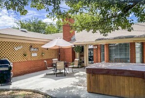 Relax in the serene backyard patio, complete with a hot tub and comfortable seating area.