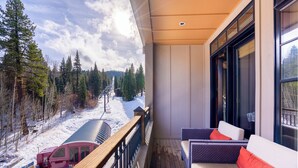 Un balcon donnant sur un paysage enneigé et sur un train.
