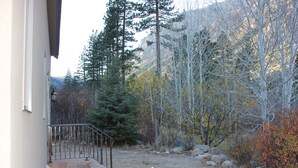 Ein Wohnhaus mit Vorgarten, einer Treppe und Blick auf eine Berglandschaft.