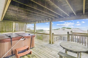 Enjoy a serene beachside retreat with a deck offering stunning views of the sandy beach and dunes.