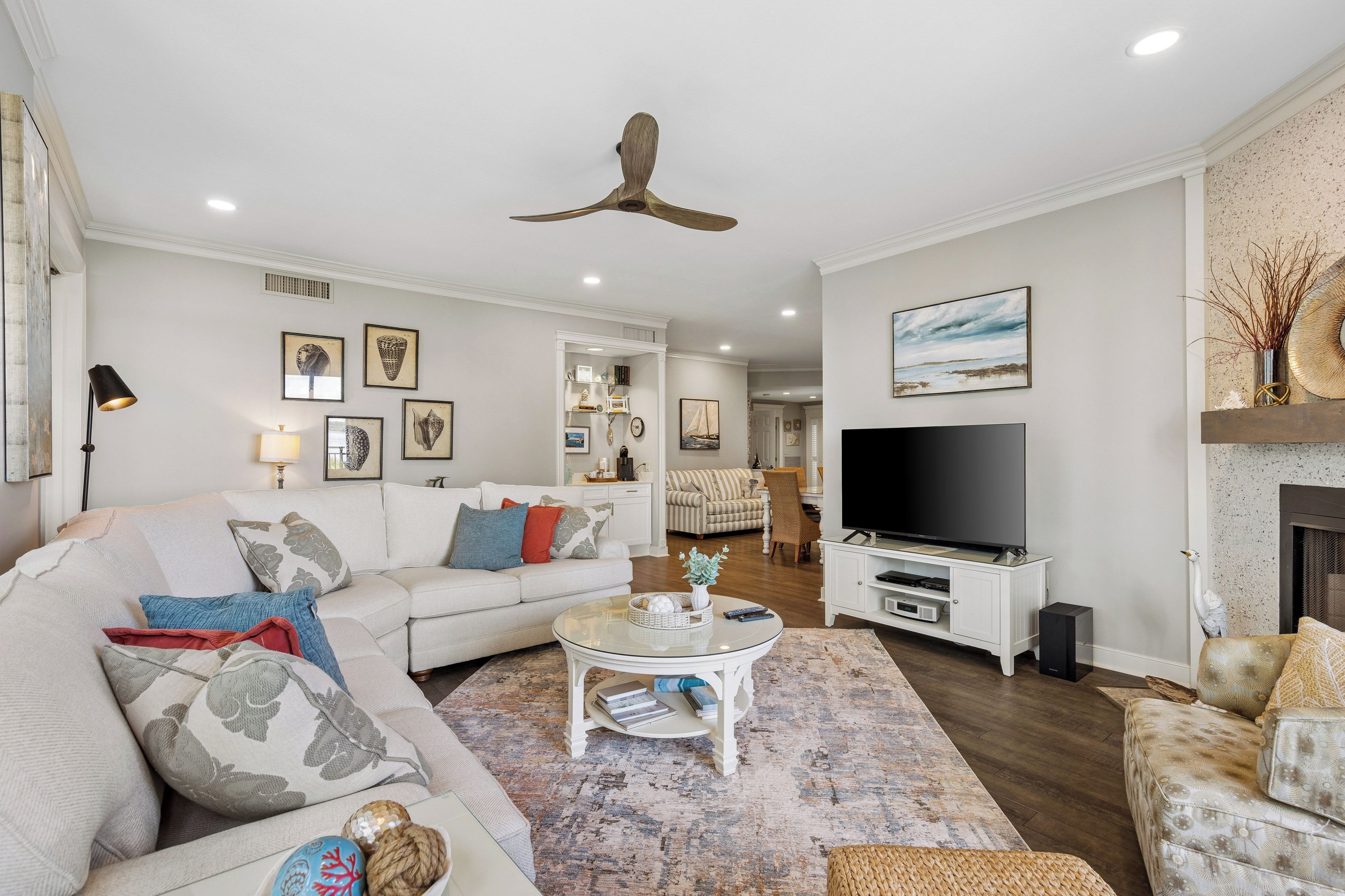 A modern living room with a sectional sofa, a flat-screen TV, and a fireplace.