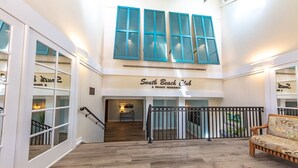 A spacious lobby with a staircase leading to a private residence labeled 'South Beach Club'. - Immaculate, 193 5-Star Reviews, Amazing Views, Updated, Pool heated/cooled (Hilton Head Island)