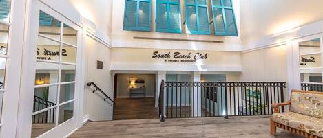 A spacious lobby with a staircase leading to a private residence labeled 'South Beach Club.'