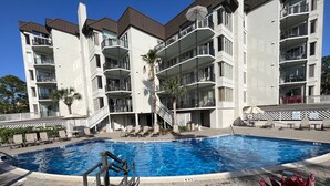 A swimming pool with a 4 ft depth marker, surrounded by a deck with lounge chairs and a palm tree. - Immaculate, 193 5-Star Reviews, Amazing Views, Updated, Pool heated/cooled (Hilton Head Island)