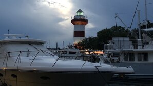 A marina with boats docked and a lighthouse in the background. - Immaculate, 193 5-Star Reviews, Amazing Views, Updated, Pool heated/cooled (Hilton Head Island)