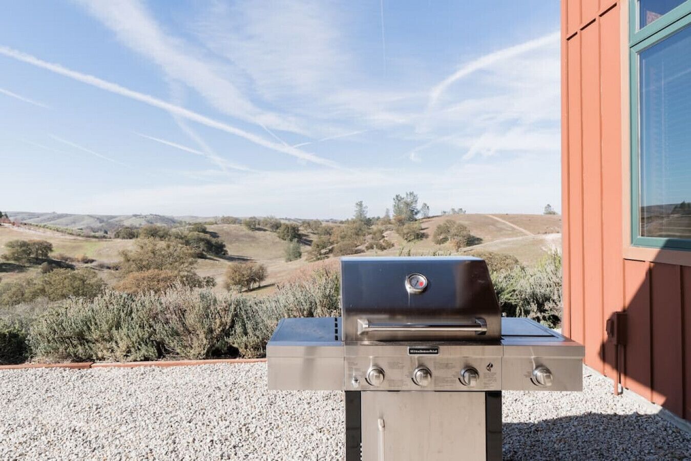 Un barbecue installé sur une terrasse, avec vue sur un paysage vallonné.