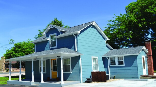 A two-story house with a porch, a chimney, and a small attached garage. - Gabouri Place ~ Completely Renovated Victorian in Ste. Genevieve's Historic Dist (Ste. Genevieve)