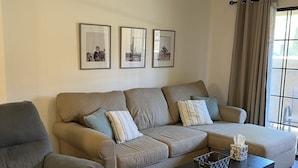 A living room with a sofa, armchair, and coffee table. There are three framed pictures on the wall. - Gated Community, Poolside, Newly Remodeled 2bed Condo (Phoenix)