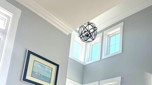 A staircase with a railing, a potted plant, and a framed picture on the wall. - Newer Ocean View home w/Pool.....Walk to Ocean and Intercoastal (Oak Island)