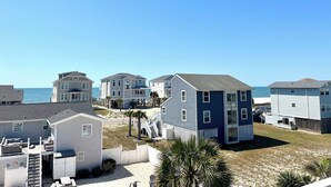 A coastal residential area with houses, a sandy beach, and a clear blue sky. - Newer Ocean View home w/Pool.....Walk to Ocean and Intercoastal (Oak Island)