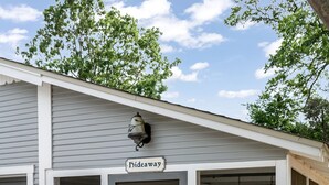 Un bâtiment avec une enseigne indiquant « Hideaway », une véranda et une porte de garage.