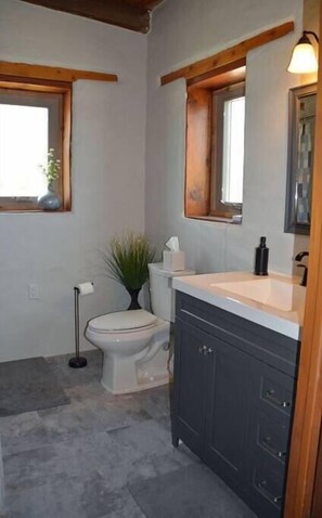 Ein Badezimmer mit Toilette, Waschbecken und Spiegel.