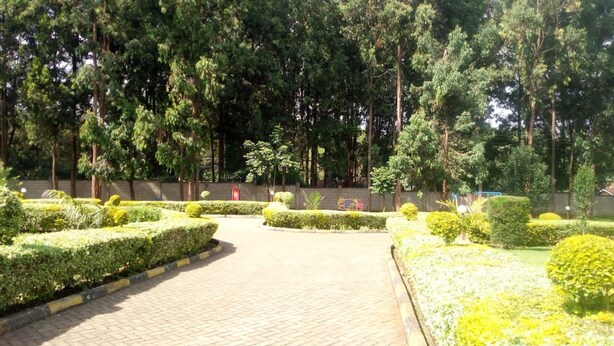 A landscaped garden with neatly trimmed hedges and a paved walkway. - Forest Breeze Gardens (Nairobi)