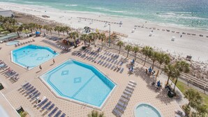 Un resort con dos piscinas, una playa y vistas al océano.