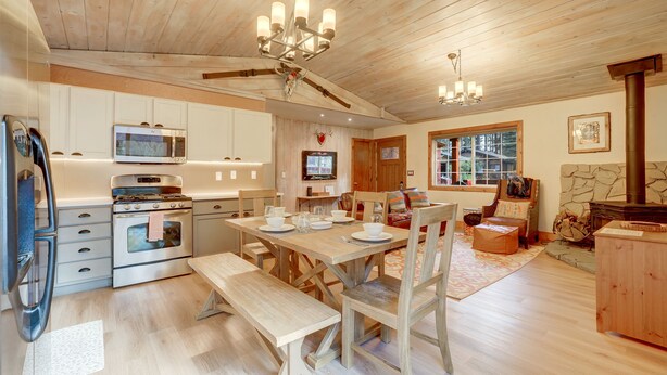 Eine geräumige Küche mit Holzschränken, einer Mikrowelle und einem Essbereich mit Holztisch und Bänken.