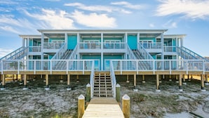 A multi-story beachfront house with a wooden deck and stairs leading to the entrance. - FloraBama Inspired Waterfront Condo w/ Boat Slip next To The Famous Florabama  (Pensacola)