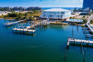 Une propriété située au bord de l’eau, dotée d’un quai, d’un grand bâtiment à la façade vitrée et d’une piscine.