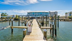 A wooden pier leading to a modern building with multiple floors and balconies. - FloraBama Inspired Waterfront Condo w/ Boat Slip next To The Famous Florabama  (Pensacola)
