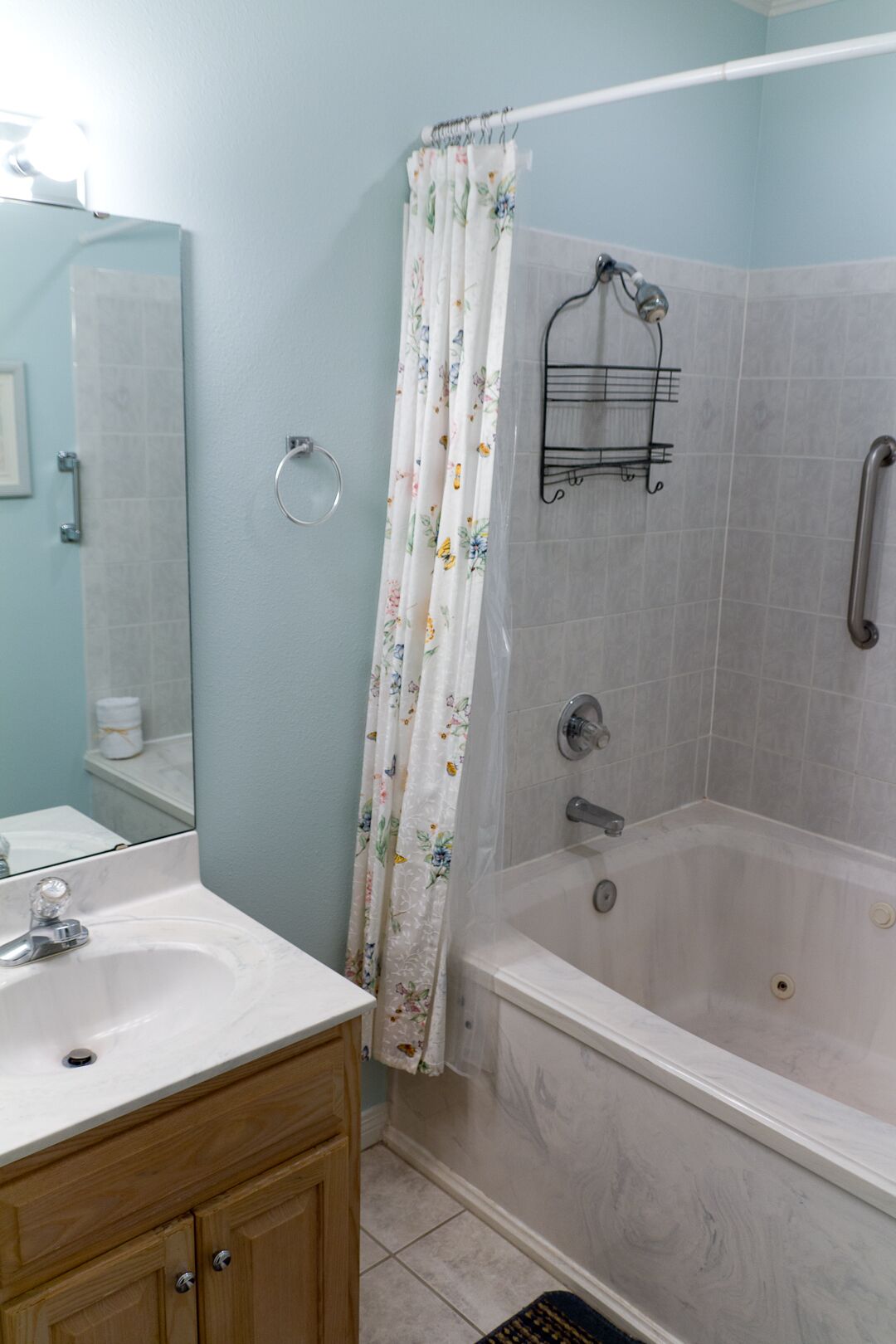 Une salle de bain avec une baignoire, une douche, un lavabo et un miroir.