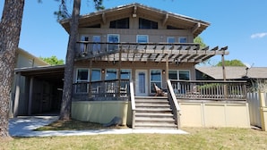Un bâtiment à deux étages, avec une façade en bois, un balcon à l’étage supérieur et une antenne parabolique sur le toit.