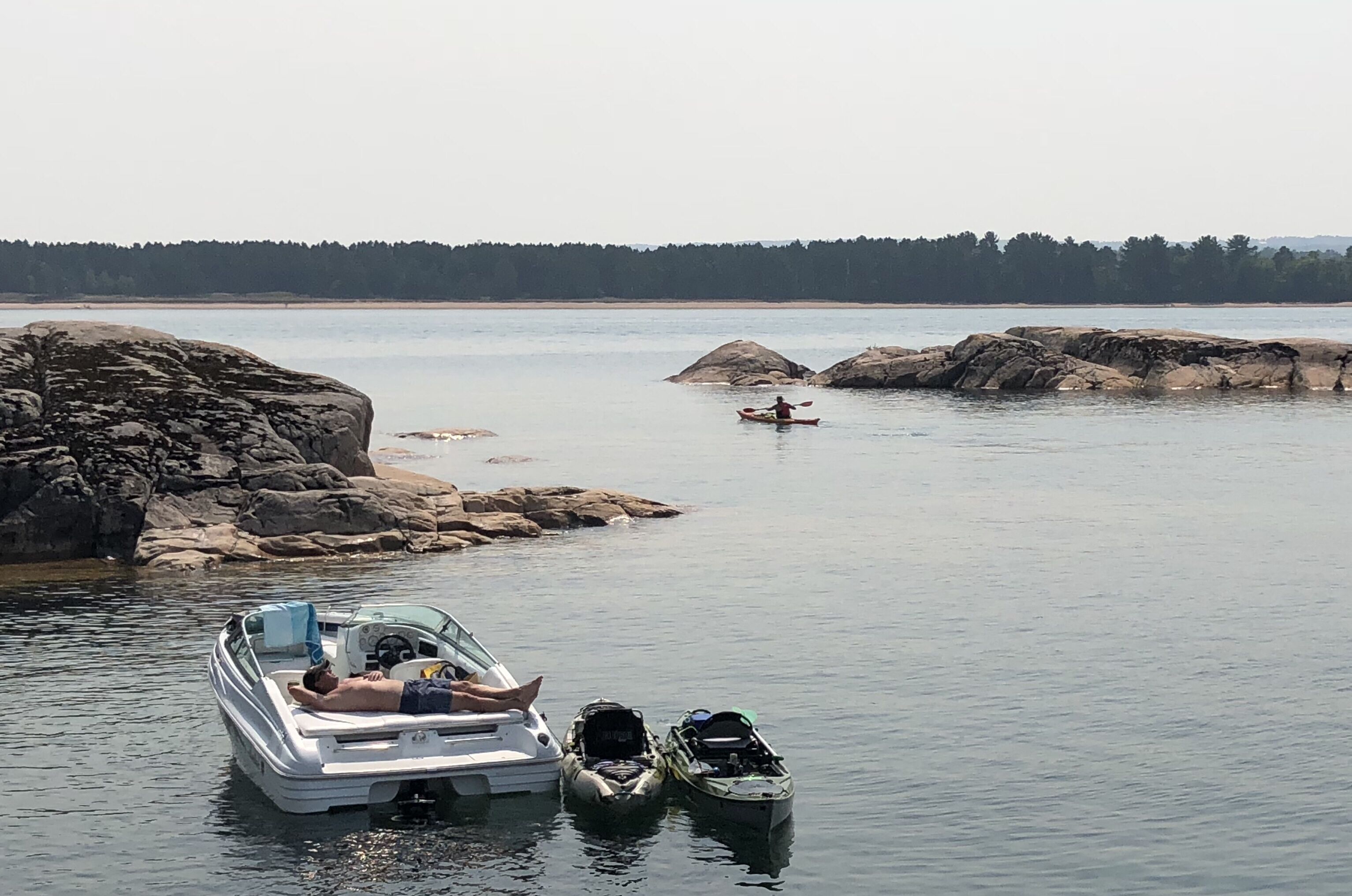 Un lago tranquilo con barcos y kayaks.