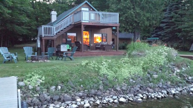 A cabin with a deck, outdoor seating, and a pond. - Quaint beautiful cabin on the southwest shore on AuTrain Lake (AuTrain)