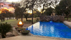 A swimming pool with a stone wall and a fire feature. - Rio de Arcadia - Two Riverside Homes, Pool & Hot Tub (Kerrville)