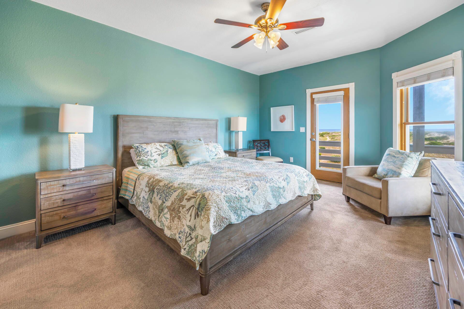 A bedroom with a bed, bedside tables, a chair, a dresser, and a ceiling fan.