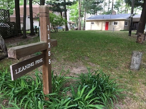 A wooden signpost with numbers 1 to 5 and a sign that reads "LEANING PINE". - Leaning Pine: A Quiet Lakefront Cottage (Interlochen)