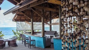 Eine Außenbar mit Meerblick, ausgestattet mit Holzmöbeln und einer blauen Bar.