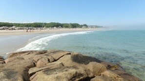 Rannalla, aurinkotuoleja, rantapyyhkeitä