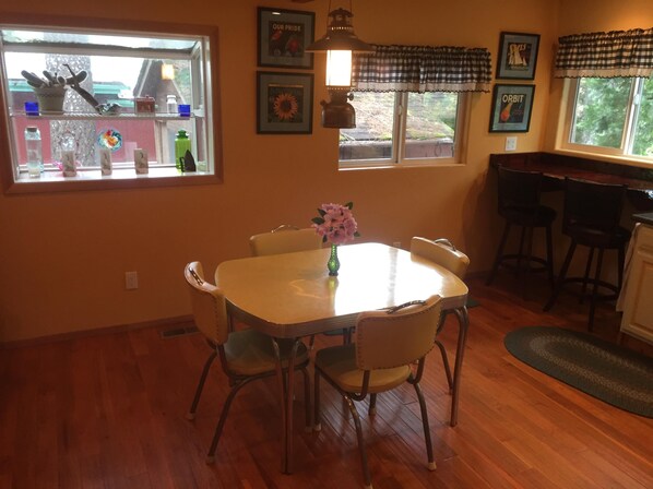 A dining area with a table and chairs, a window with a view, and a bar area.