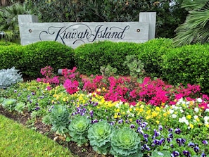 Un letrero que dice 'Kiawah Island' rodeado por un colorido jardín de flores.