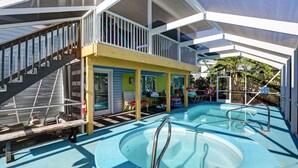 Ein Poolbereich mit verglaster Terrasse, einer Treppe und einer Lounge mit Außenmöbeln.