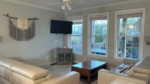 Una sala de estar con un sofá modular, una mesa de centro, un televisor y un mueble.
